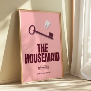 May include: Framed poster with a pink backdrop, a key and tooth graphic. The title "THE HOUSEMAID" is in dark red letters. Text includes "IN THEATRES DECEMBER 19 DIRECTED BY PAUL FEIG" and the quote: "HAVING TEETH IS A PRIVILEGE."