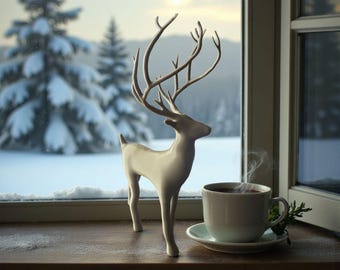 May include: A white ceramic deer figurine with large antlers stands on a wooden surface next to a cup of coffee. The cup sits on a saucer with a sprig of greenery. A snowy winter landscape is visible through the window.