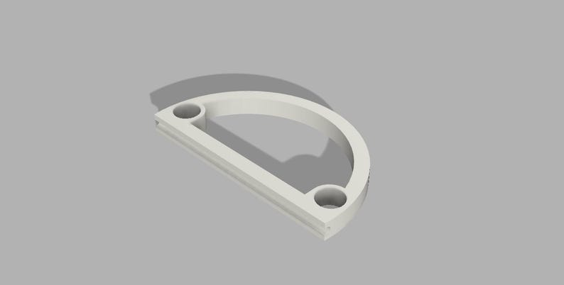 May include: White plastic half-circle frame with two holes. The frame is designed to hold a round object, such as a clock face.