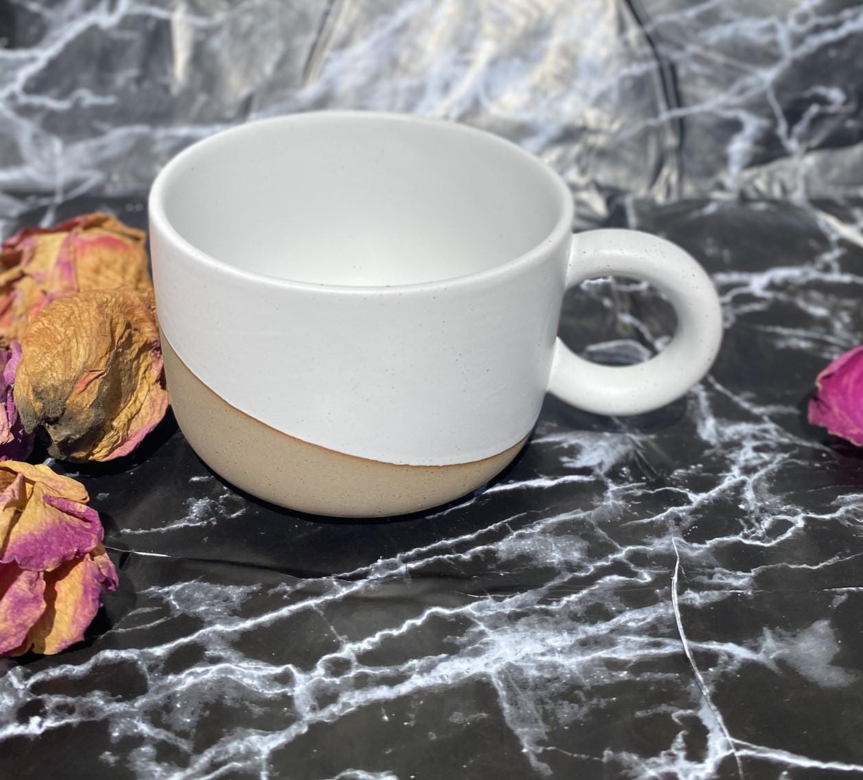 Elegant ceramic mug in white and raw earthenware mix. A wide coffee cup with brown freckles. Rustic cup for latte, tea, or cappuccino lovers