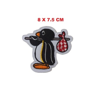 Può includere: Toppa ricamata raffigurante un pinguino dei cartoni animati che trasporta un fagotto su un bastone. Il pinguino è bianco e nero con zampe arancioni e becco giallo. Misura 8 x 7,5 cm.