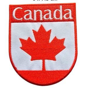 Pode incluir: Um emblema bordado em forma de escudo com a palavra Canada em letras brancas sobre um fundo vermelho, acima de um campo branco com uma folha de bordo vermelha. O emblema mede 6 x 7,5 cm e tem uma borda vermelha com costuras detalhadas.