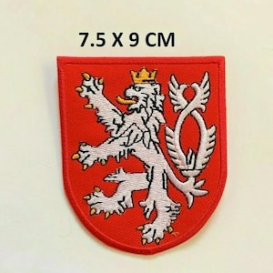 May include: Red embroidered patch with a white lion and a crown. The lion is standing on its hind legs with its tail curled around its body. The patch is 7.5 x 9 cm.
