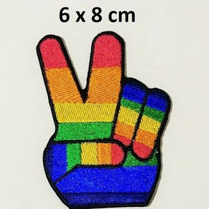 May include: Rainbow peace sign iron-on patch, 6 x 8 cm. The patch features a hand making the peace sign with the colors of the rainbow.