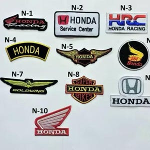 K&ouml;nnte beinhalten: Eine Sammlung gestickter Honda-Aufn&auml;her in verschiedenen Designs. Enth&auml;lt Patches mit dem Honda-Logo, "Honda Racing", "Service Center" und "Goldwing". Die Patches haben rote, schwarze, goldene und wei&szlig;e Farben. Ma&szlig;e in Zentimetern.