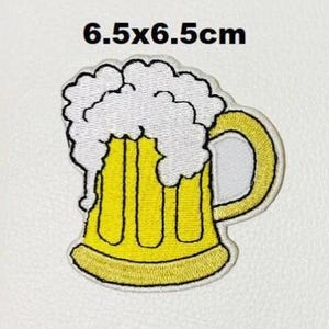 May include: An embroidered iron-on patch of a beer stein with foam on top. The patch is 6.5 x 6.5 cm.