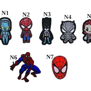 Puede incluir: Parches bordados con varios personajes de cómics, incluyendo a Spider-Man y Batman. Los parches son coloridos y detallados, con una variedad de diseños y formas. Los parches están etiquetados con las letras N1 a N7.