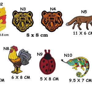 May include: A collection of embroidered patches featuring various designs. Includes a yellow bear with a red shirt, a fox, a penguin, a rooster, a ladybug, a chameleon, a duck, and a black and white whale. Sizes vary.