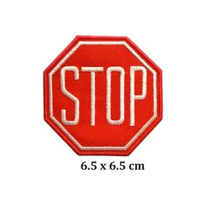May include: Embroidered red stop sign patch with white border and white "STOP" text. The patch measures 6.5 x 6.5 cm, or approximately 2.5 x 2.5 inches. Perfect for jackets, bags, or other fabric items.