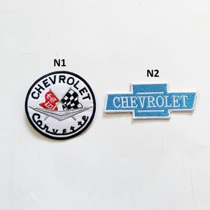以下が含まれることがあります： N1とN2とラベル付けされた2つの刺繍ワッペン。N1はシボレーコルベットのロゴ、赤い旗、チェッカーフラッグ、Chevrolet Corvetteの文字が入った円形のワッペン。N2はChevroletの文字が入った水色の長方形のワッペン。