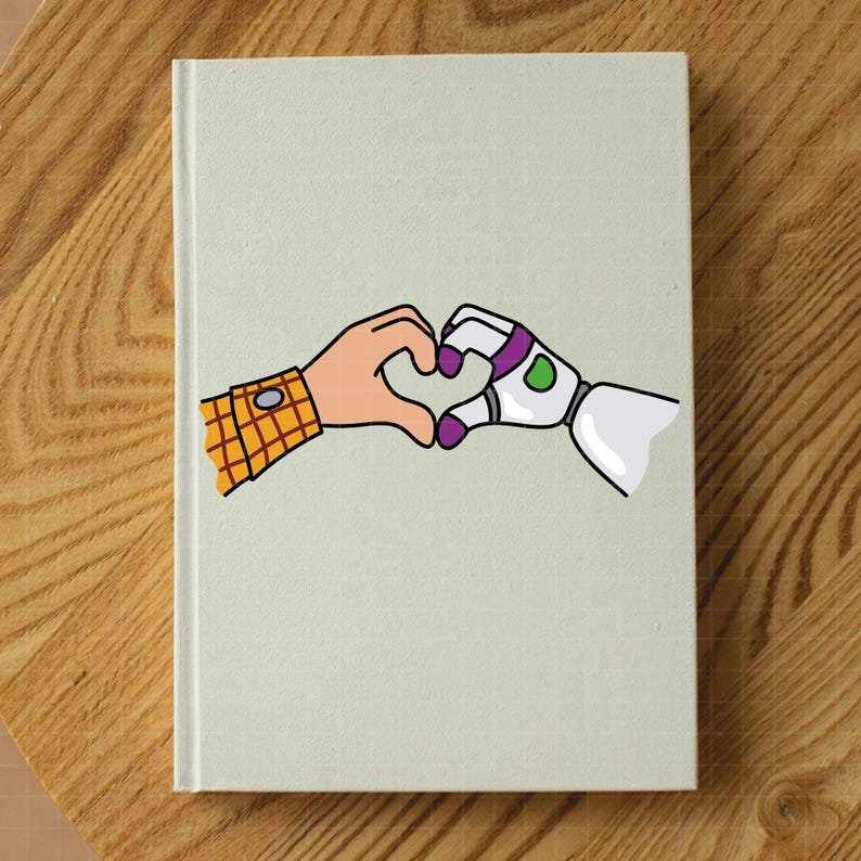 May include: A hardcover notebook with a light green cover. The cover features a cartoon illustration of two hands forming a heart shape. One hand is a human hand with a yellow plaid shirt sleeve, and the other is a robot hand.