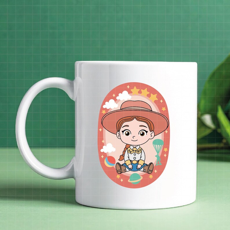 May include: White ceramic mug featuring a cartoon illustration of a cowgirl character in a pink oval frame. The design includes stars, clouds, and planets. The mug has a large, curved handle.