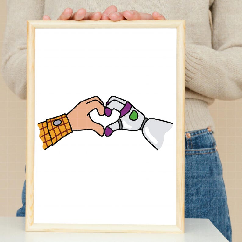 May include: A framed print featuring a heart shape formed by two cartoon hands. One hand is a human hand with a plaid cuff, and the other is a robotic hand with purple and green accents. The background is white.