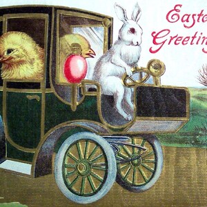 Könnte beinhalten: Vintage Ostergrußkarte mit einem weißen Hasen, der ein grünes und schwarzes Auto fährt, mit zwei Küken als Passagiere. Der Text "Easter Greetings" ist in roter Schrift. Das Auto hat goldene Akzente und weiße Räder.