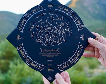 May include: A black circular planisphere star chart featuring gold constellations, months, and zodiac signs. The text reads Planisphere, The Brightest Stars & Deep Sky Objects Made Visible For Every Hour Every Year, and 30-45 North Latitude.