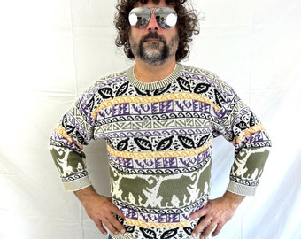 May include: A white sweater with a multi-colored pattern of elephants, leaves, and geometric shapes. The sweater has long sleeves and a crew neck.