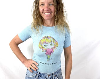 Vintage 1970-tals blåribbad sliten Blythe-skjorta med stora ögon, figursydd för dam - "Jag behöver också kärlek"