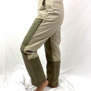 Puede incluir: Pantal&oacute;n de trabajo beige y verde con un parche en la rodilla y un bolsillo lateral. El pantal&oacute;n tiene cierre de bot&oacute;n y trabillas para el cintur&oacute;n.