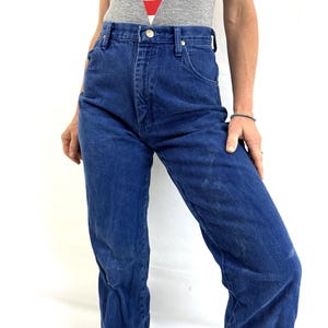 K&ouml;nnte beinhalten: Eine Jeanshose mit hohem Bund in Blau mit geradem Bein. Die Jeans hat einen klassischen F&uuml;nftaschen-Stil und einen Knopfverschluss.
