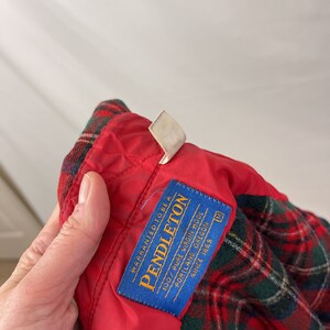 May include: A blue label with white text that reads "WARRANTED TO BE A PENDLETON 100% PURE VIRGIN WOOL PORTLAND, OREGON SINCE 1869" with a size tag that reads "M".