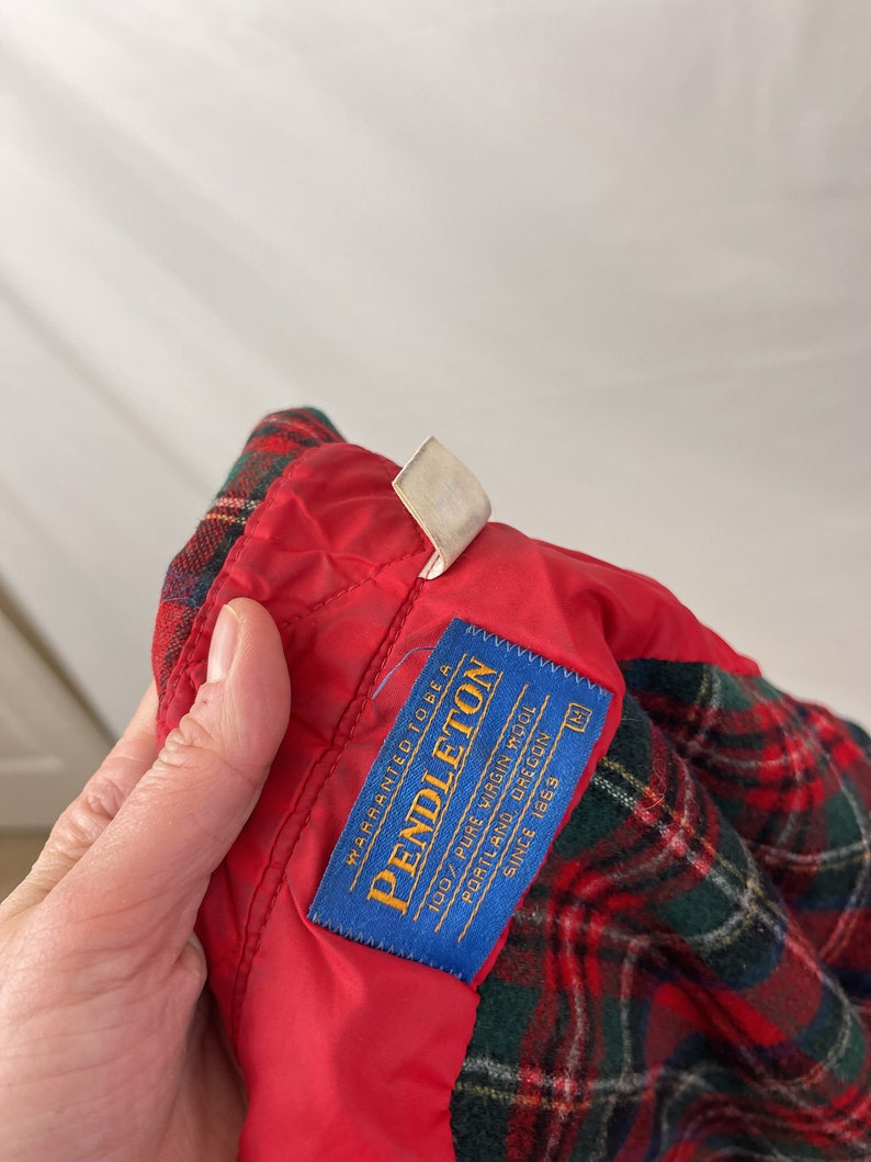 May include: A blue label with white text that reads "WARRANTED TO BE A PENDLETON 100% PURE VIRGIN WOOL PORTLAND, OREGON SINCE 1869" with a size tag that reads "M".