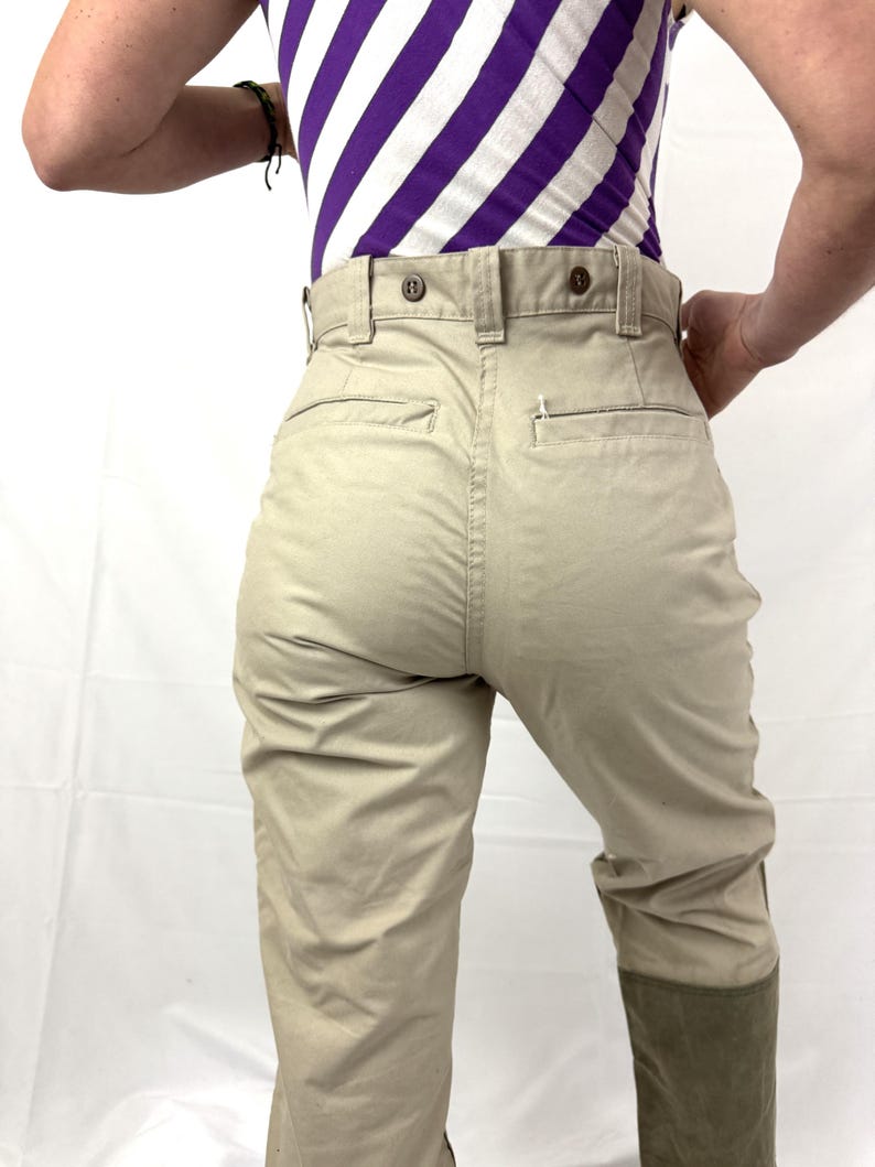 Puede incluir: Pantal&oacute;n beige de cintura alta con cierre de bot&oacute;n. El pantal&oacute;n tiene un bolsillo de parche en la parte posterior derecha y una costura en el centro de la espalda. El pantal&oacute;n est&aacute; doblado en la parte inferior y tiene un parche de tela marr&oacute;n en la parte inferior de las piernas.