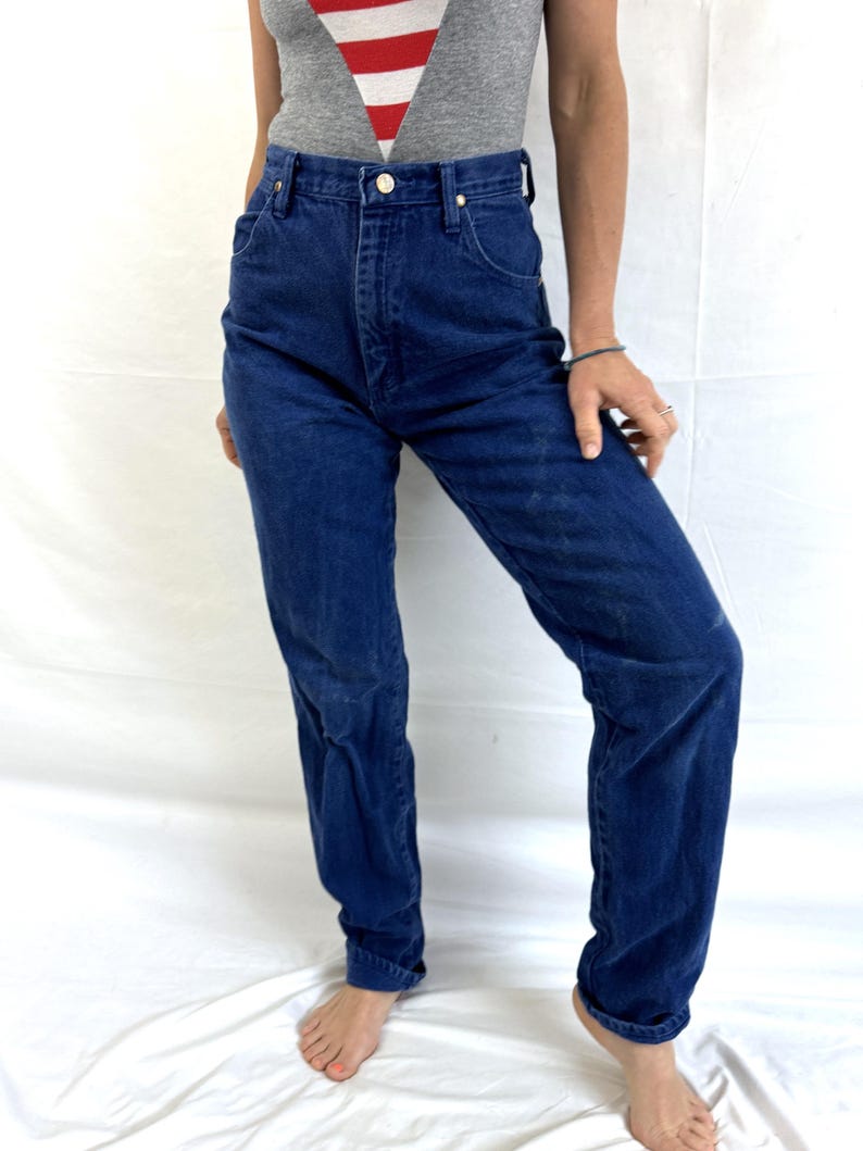 K&ouml;nnte beinhalten: Eine Jeanshose mit hohem Bund und geraden Beinen in blauer Denim-Farbe.