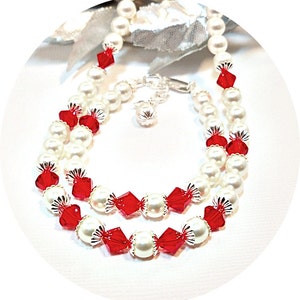 以下が含まれることがあります： 白い真珠と赤いクリスタルビーズの2連ブレスレット