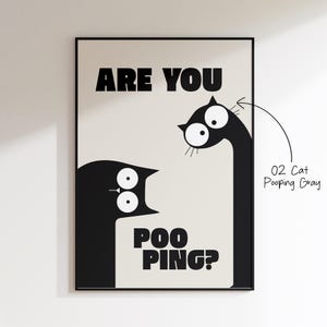 May include: Black framed art print featuring two stylized black cats on a cream background. The text "ARE YOU POO PING?" is displayed in bold, black capital letters. The print is labeled "02 Cat Pooping Gray".