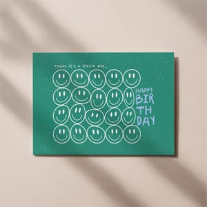 Könnte beinhalten: Eine grüne Geburtstagskarte mit weißen Smiley-Gesichtern. Der Text "Happy Birthday" ist blau. Der Text "Today it's a special day..." steht oben auf der Karte.