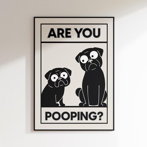 May include: Black and white framed print featuring two cartoon pugs with exaggerated expressions. The text "ARE YOU" is above the pugs, and "POOPING?" is below. The pugs are set against a cream-colored background.