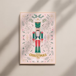 May include: A framed print featuring a festive nutcracker illustration. The nutcracker is dressed in a green and red uniform, with a black mustache and a green hat. The words "Magical Christmas Time" are written in gold script.