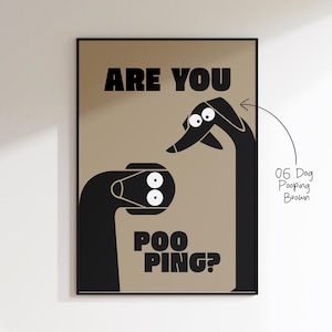 Hochformatiges, grafisches Bad-Poster in Taupe. Links und rechts strecken zwei stilisierte, schwarze Hunde ihre Hälse ins Bild; die weißen Kulleraugen sorgen für Comedy. In der Mitte bricht der typografische Gag „ARE YOU / POO / PING?“