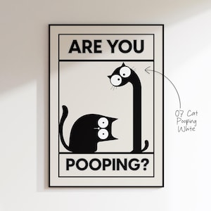 May include: Black and white framed art print featuring a cartoon cat with the text "ARE YOU POOPING?". The cat is depicted in a humorous pose, with one cat looking up at another cat with a long neck.
