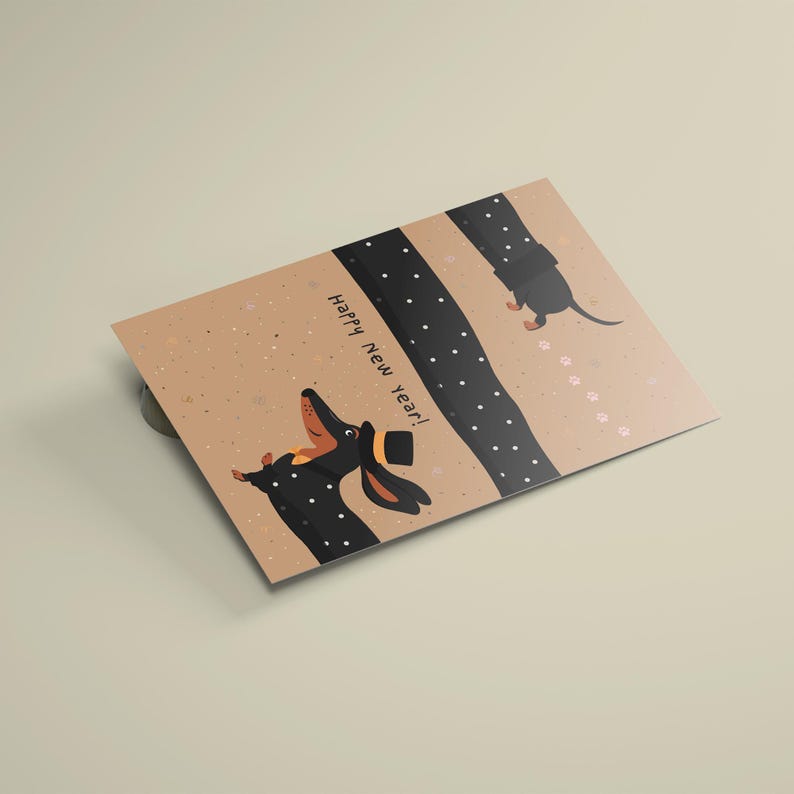 May include: A greeting card with a tan background features a cartoon illustration of a dachshund wearing a top hat. The text "Happy New Year!" is printed on the card. The dog is black with tan ears and a tan snout. A dotted black line and paw prints are also on the card.