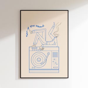 Könnte beinhalten: Gerahmter Kunstdruck mit einer blauen Strichzeichnung einer Person auf einem Plattenspieler. Der Text "Turn up the volume" ist in blauer Schrift geschrieben. Das Kunstwerk befindet sich vor einem cremefarbenen Hintergrund.