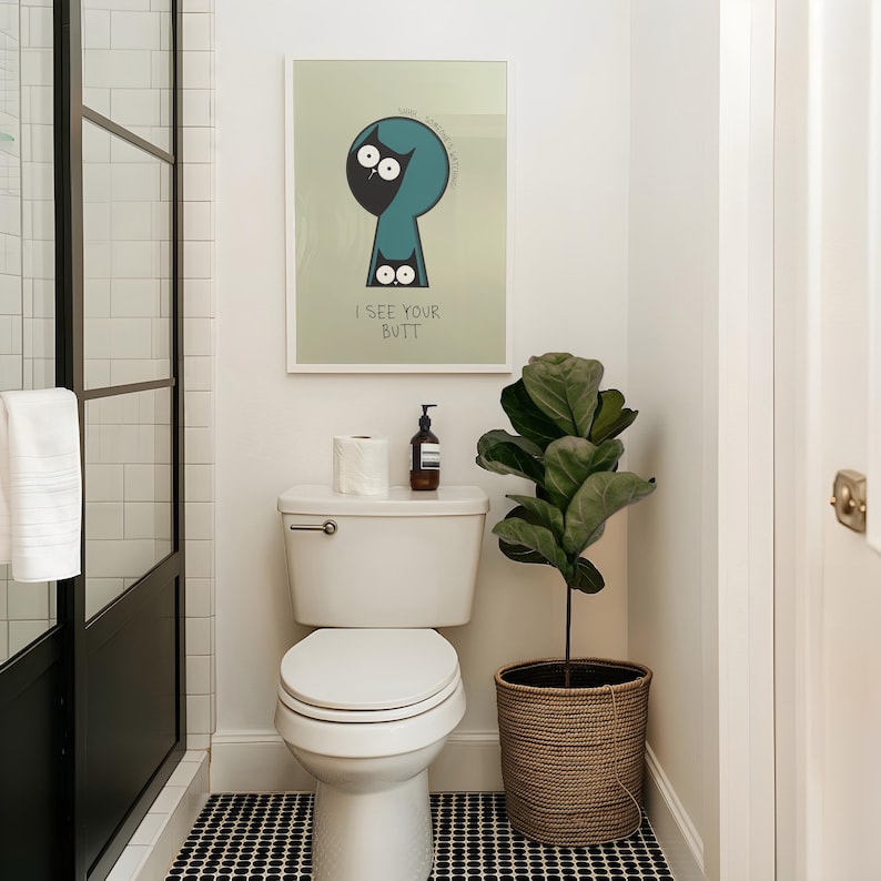 May include: A bathroom scene featuring a white toilet, a framed art print with the text "I SEE YOUR BUTT", and a potted plant. The floor has a black and white tile pattern. A roll of toilet paper and a soap dispenser are on the toilet tank.