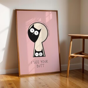 May include: Framed art print featuring a black cat peering through a keyhole shape on a pink background. The text reads "SHHH SOMEONE'S WATCHING" and "I SEE YOUR BUTT". The artwork is in a wooden frame.