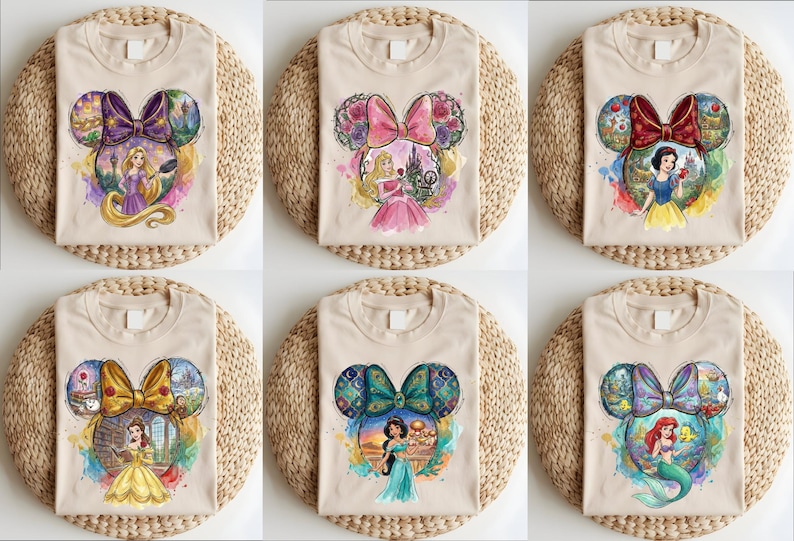 May include: Beige t-shirts featuring a Mickey Mouse head design with a bow and princess illustrations. Each shirt showcases a different princess: Rapunzel, Aurora, Snow White, Belle, Jasmine, and Ariel. The shirts are displayed on woven placemats.