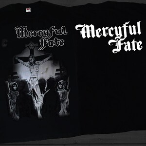 Może przedstawiać: Czarny T-shirt z białym nadrukiem graficznym z logo zespołu "Mercyful Fate" i postacią na krzyżu. Na plecach koszulki znajduje się nazwa zespołu nadrukowana na biało.
