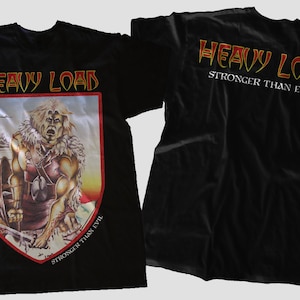 Peut inclure: T-shirt noir avec l'inscription "HEAVY LOAD" en rouge et or. Le devant présente un guerrier dans un bouclier, avec "STRONGER THAN EVIL". Le dos porte également "HEAVY LOAD" et "STRONGER THAN EVIL". Vêtement sur le thème du rock.