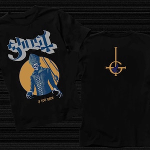 Può includere: T-shirt nera con grafica di una figura in abito blu e nero con sfondo giallo e la scritta "Ghost" in bianco e blu. Il retro della maglietta presenta un simbolo oro e blu. Il testo "IF YOU HAVE" è in basso.