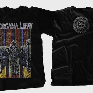 Könnte beinhalten: Schwarzes T-Shirt mit einem Motiv einer Kapuzenfigur, die einen Schädel hält, und dem Text "Morgana Lefay" und "Magisterium". Die Rückseite des Shirts hat ein Pentagramm-Design.
