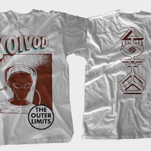 May include: White t-shirt with a red and blue graphic of an alien wearing a helmet and the text "Voivod The Outer Limits". The back of the shirt has a red graphic of a symbol with an eye.
