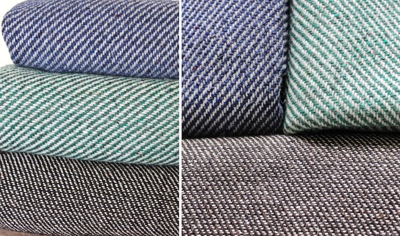 K&ouml;nnte beinhalten: Nahaufnahme von gefalteten Stoffmustern in Blau, Gr&uuml;n und Schwarz. Jeder Stoff hat ein diagonales Fischgr&auml;tmuster. Der blaue Stoff hat wei&szlig;e Akzente, der gr&uuml;ne hat wei&szlig;e Akzente und der schwarze hat wei&szlig;e Akzente.
