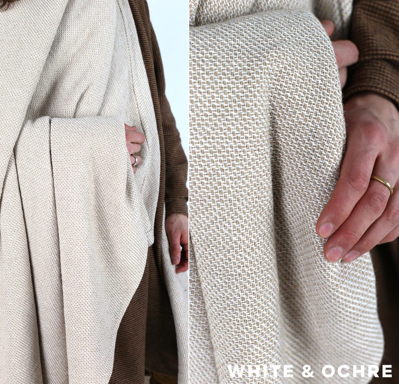 K&ouml;nnte beinhalten: Eine gewebte Decke in Wei&szlig;- und Ockert&ouml;nen. Die Decke hat ein strukturiertes Aussehen und ist drapiert. Der Text "WHITE & OCHRE" ist in der unteren rechten Ecke sichtbar.