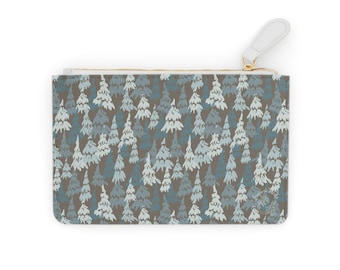 Può includere: Pochette rettangolare con un motivo ripetuto di alberi sempreverdi stilizzati in tonalità blu e bianco su sfondo marrone. Ha una cerniera dorata e un tirante in pelle bianca.