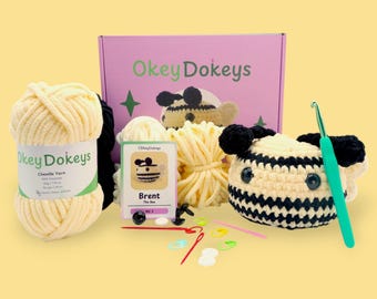 May include: A crochet bee kit with yellow chenille yarn, a crochet hook, safety eyes, and a card with the text "Brent The Bee".