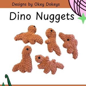 May include: A digital pattern document titled Okey Dokeys Designs by Okey Dokeys Dino Nuggets featuring four brown crocheted dinosaur figures with black bead eyes. The document includes a pink yarn ball graphic, a green crochet hook, and text.