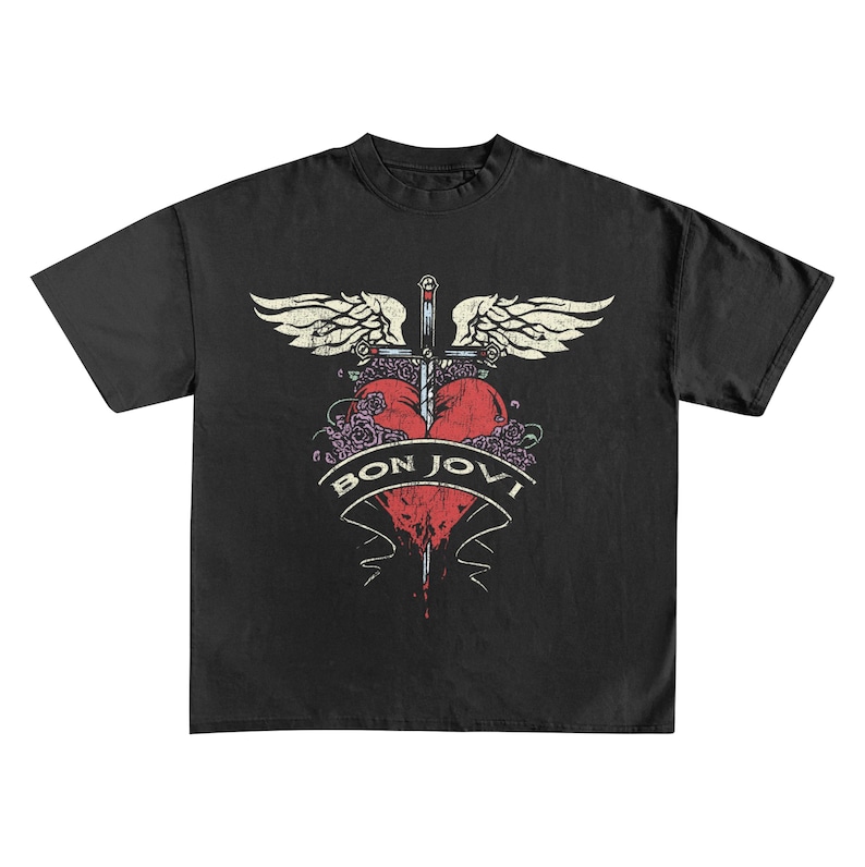 May include: Black t-shirt featuring a distressed graphic. The design includes a red heart pierced by a sword, with wings and roses. The text "BON JOVI" is displayed on a banner below the heart. The shirt has a classic crew neck.